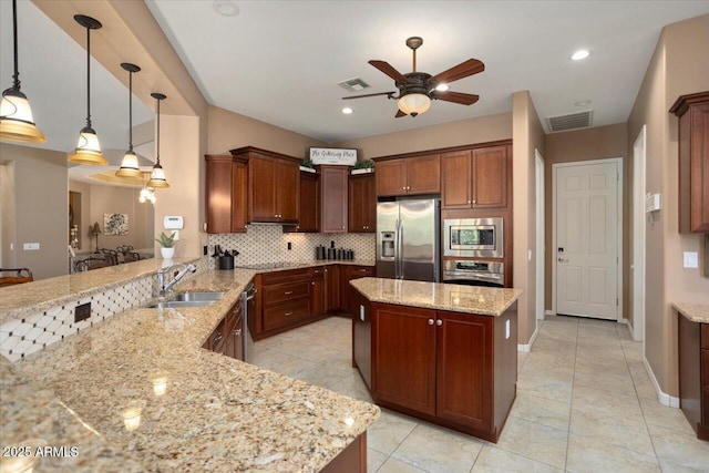 kitchen with sink, kitchen peninsula, pendant lighting, stainless steel appliances, and light stone countertops