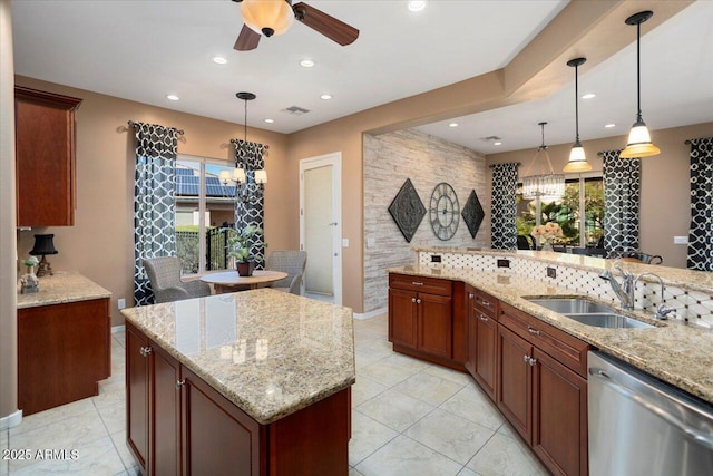 kitchen featuring sink, hanging light fixtures, stainless steel dishwasher, a kitchen island, and light stone countertops