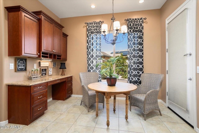 dining space with a notable chandelier, light tile patterned floors, and built in desk