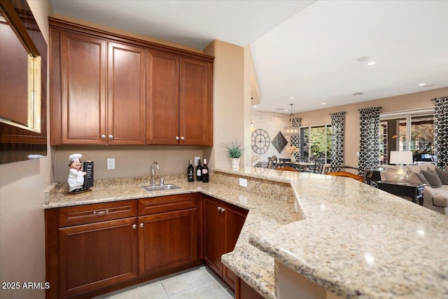 kitchen featuring sink, light tile patterned floors, light stone countertops, and kitchen peninsula