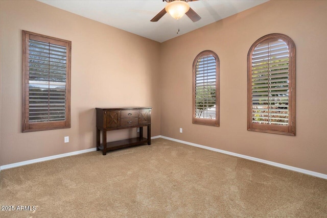 carpeted spare room featuring ceiling fan