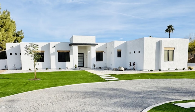 view of front of house featuring a front lawn and stucco siding