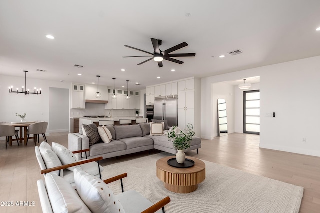 living room with light wood-style floors, baseboards, visible vents, and recessed lighting