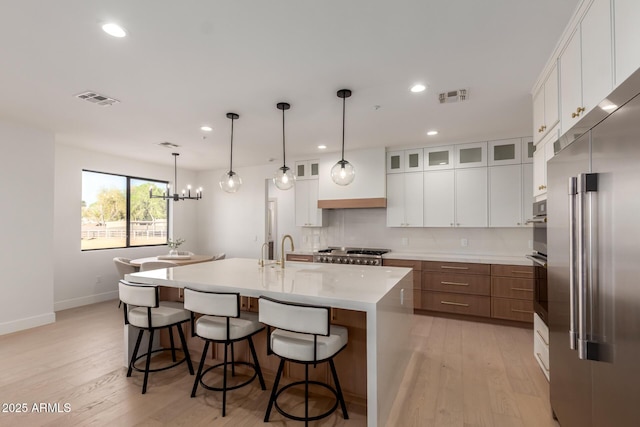 kitchen featuring light countertops, appliances with stainless steel finishes, visible vents, and white cabinets