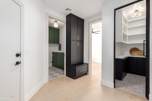 interior space featuring light wood-type flooring, visible vents, and baseboards