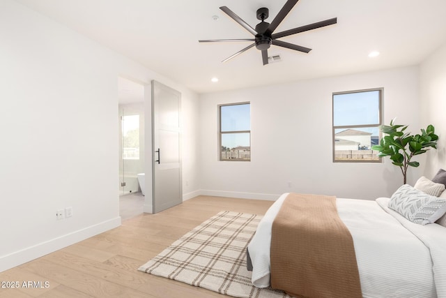 bedroom with light wood-style floors, visible vents, baseboards, and multiple windows