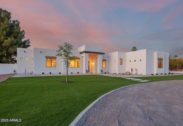 view of front of property featuring a lawn and stucco siding