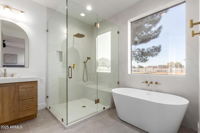 bathroom with a stall shower, vanity, and a wealth of natural light