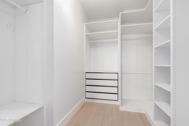 walk in closet with wood finished floors