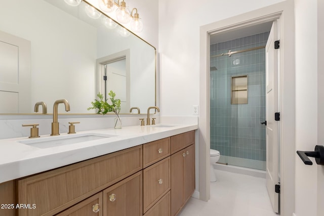 bathroom featuring toilet, a stall shower, double vanity, and a sink