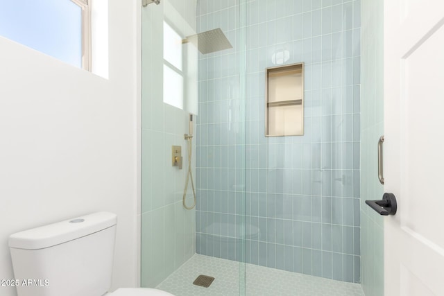 full bath with a tile shower and toilet