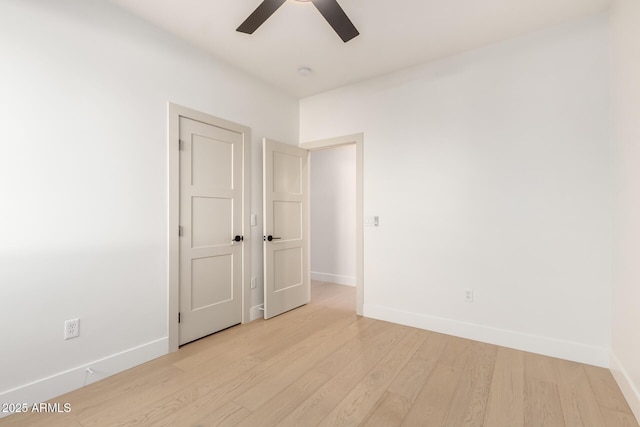 unfurnished room featuring light wood-style floors, ceiling fan, and baseboards