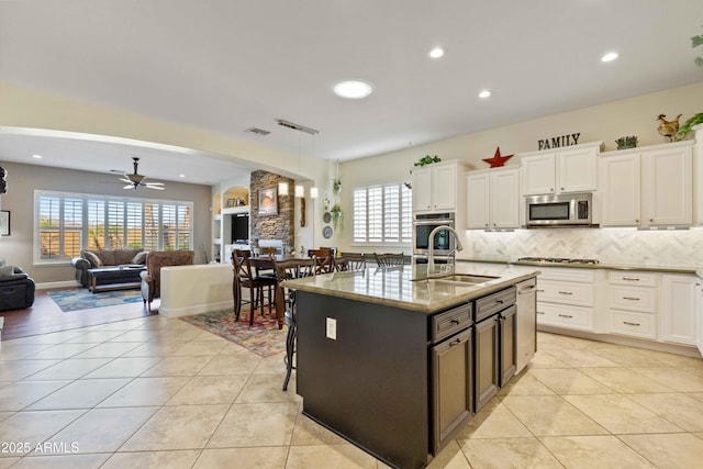 5122 S Miller Pl, Chandler, AZ 85249 - kitchen with stainless steel microwave, recessed lighting, a sink, backsplash, and open floor plan