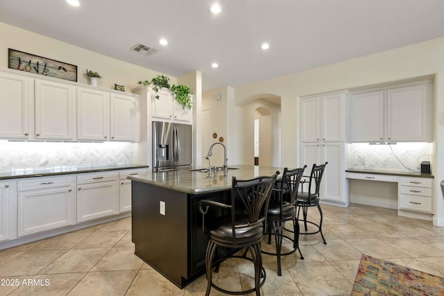5122 S Miller Pl, Chandler, AZ 85249 - kitchen featuring arched walkways, stainless steel fridge with ice dispenser, backsplash, a sink, and visible vents