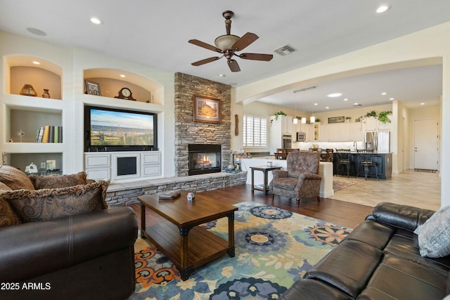 5122 S Miller Pl, Chandler, AZ 85249 - living area with recessed lighting, light wood-type flooring, a ceiling fan, visible vents, and a stone fireplace
