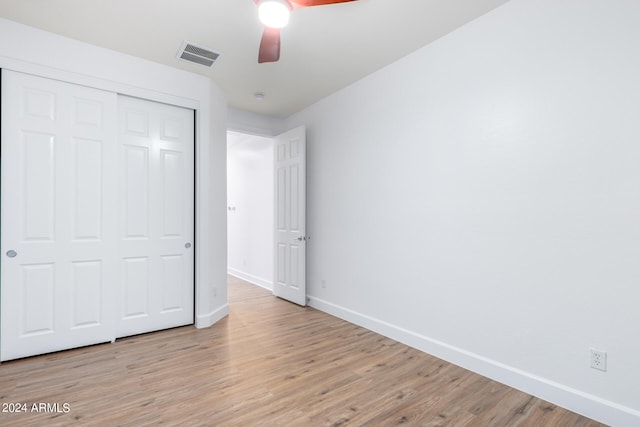 unfurnished bedroom with ceiling fan, a closet, and light hardwood / wood-style flooring