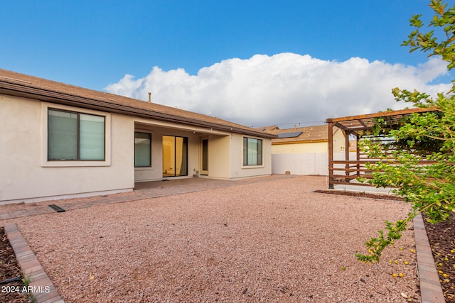 rear view of property featuring a pergola and a patio