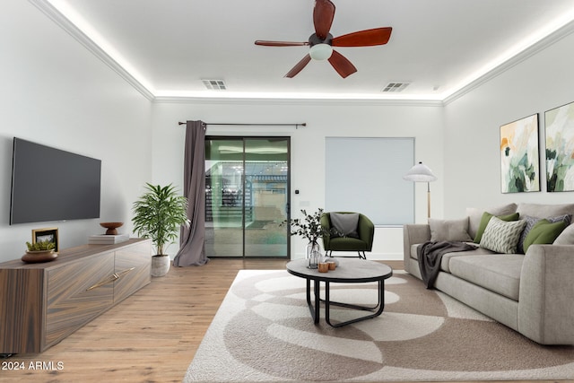 living room featuring ornamental molding, light wood-type flooring, and ceiling fan