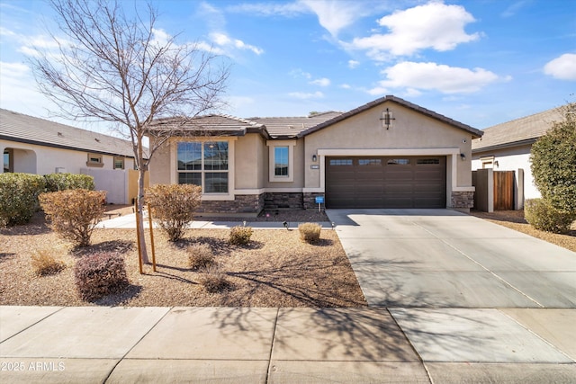 view of front of home with driveway, stone siding, a tiled roof, an attached garage, and stucco siding