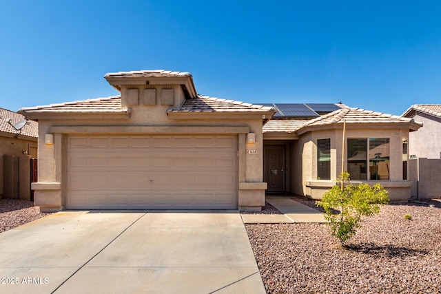 1634 E Harwell Rd, Phoenix, AZ 85042 - view of front of home with a tiled roof, a garage, concrete driveway, stucco siding, and solar panels
