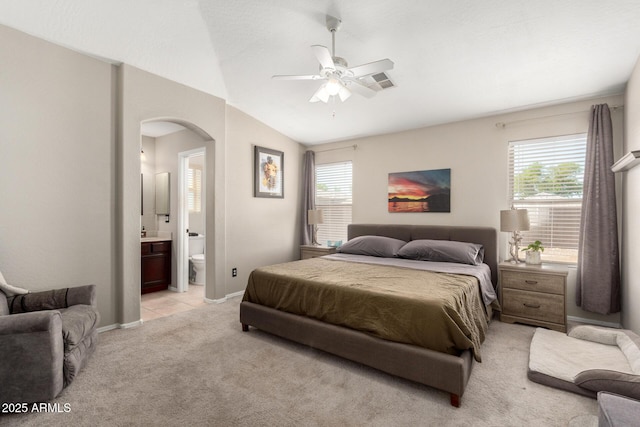 1634 E Harwell Rd, Phoenix, AZ 85042 - bedroom with light colored carpet, arched walkways, vaulted ceiling, baseboards, and connected bathroom