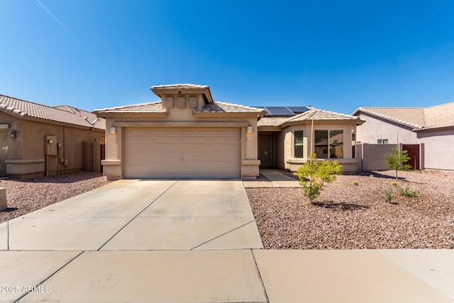 1634 E Harwell Rd, Phoenix, AZ 85042 - view of front of house with stucco siding, roof mounted solar panels, a tile roof, a garage, and concrete driveway