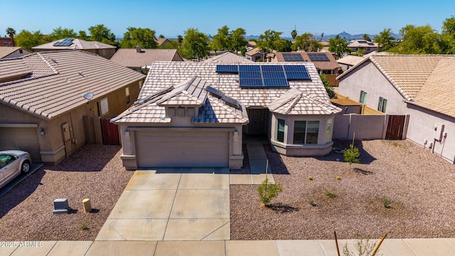 1634 E Harwell Rd, Phoenix, AZ 85042 - view of front of house featuring an attached garage, stucco siding, driveway, roof mounted solar panels, and a residential view