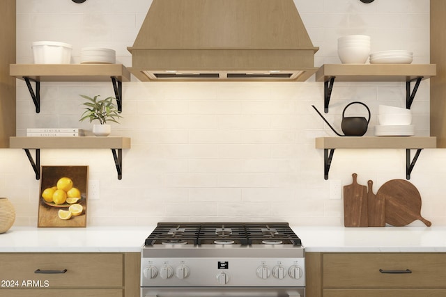 kitchen with premium range hood, stainless steel range with gas cooktop, and decorative backsplash