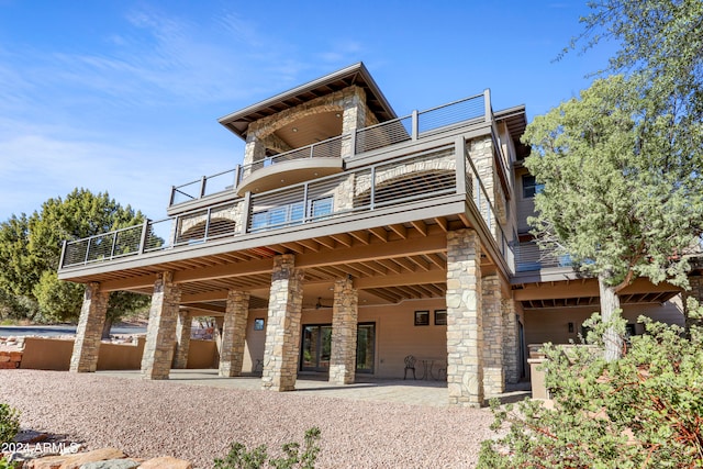 rear view of property featuring a patio area and a balcony