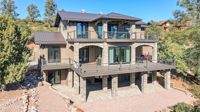 rear view of property featuring a patio and a balcony