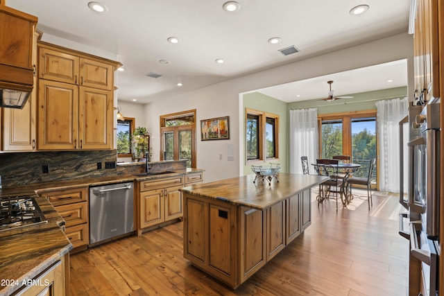 kitchen with light hardwood / wood-style floors, a center island, stainless steel appliances, and sink