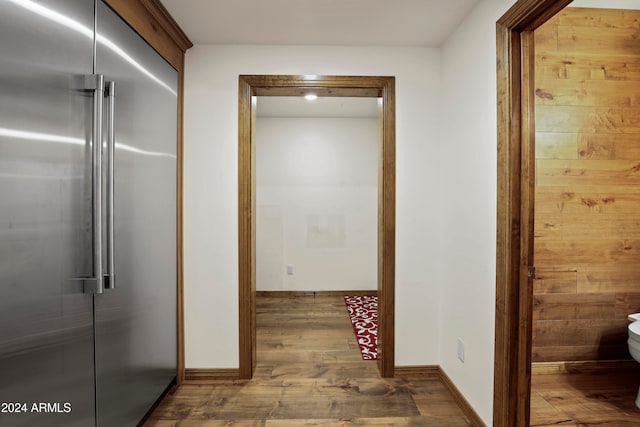 hall with wooden walls and dark wood-type flooring