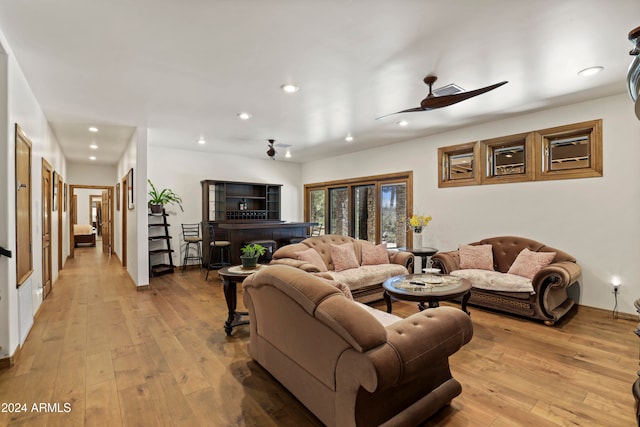 living room with ceiling fan and light hardwood / wood-style floors