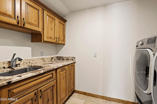 laundry area with sink, light tile patterned floors, cabinets, and washer / dryer