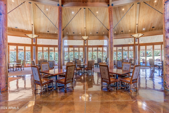 dining area featuring a towering ceiling, a wealth of natural light, and wooden ceiling