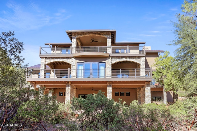 back of property featuring ceiling fan and a balcony