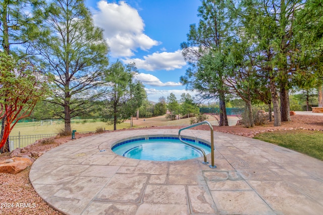 view of swimming pool with an in ground hot tub