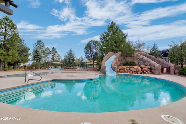 view of swimming pool featuring a patio and a water slide