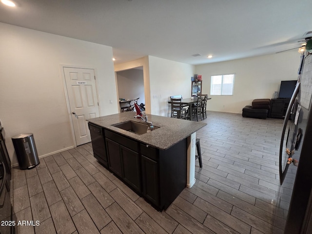 kitchen featuring sink, a kitchen breakfast bar, an island with sink, and dishwasher