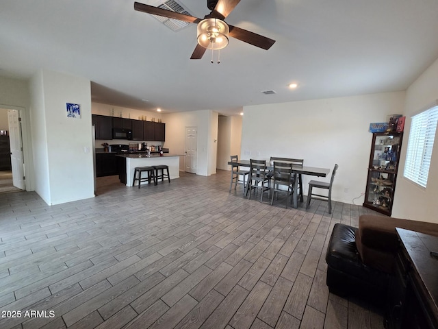 living room with ceiling fan and light hardwood / wood-style floors