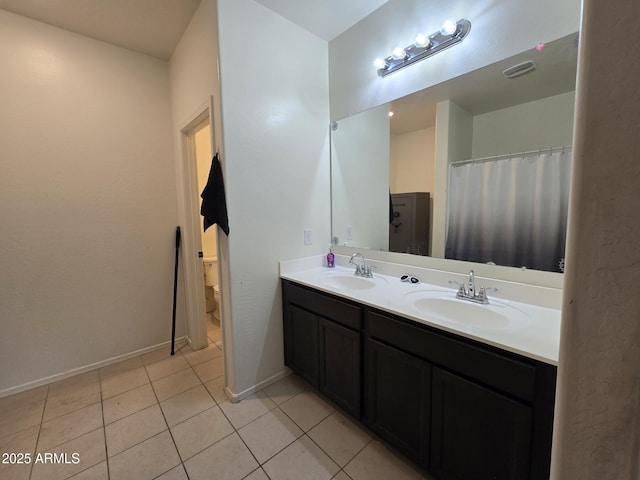 bathroom featuring tile patterned flooring, vanity, and toilet