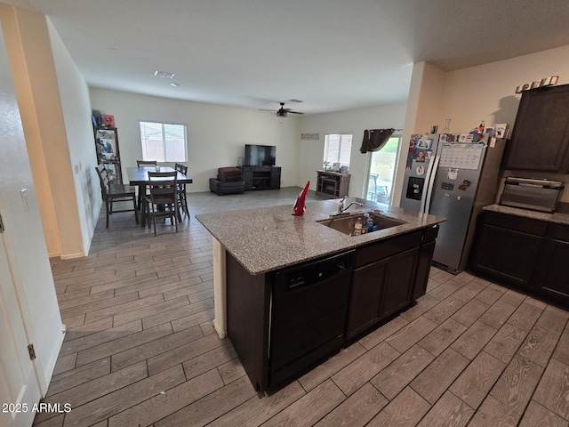 kitchen with plenty of natural light, black dishwasher, sink, and a center island with sink