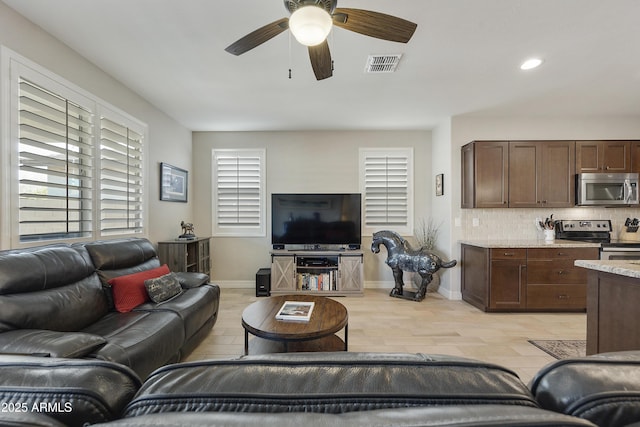 living room with light wood-type flooring and ceiling fan