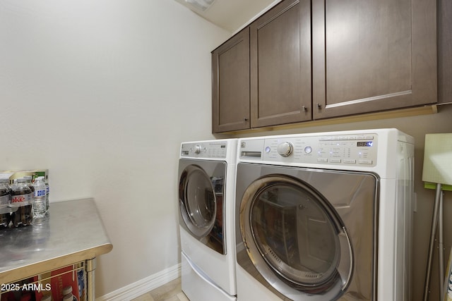 clothes washing area with washing machine and dryer and cabinets