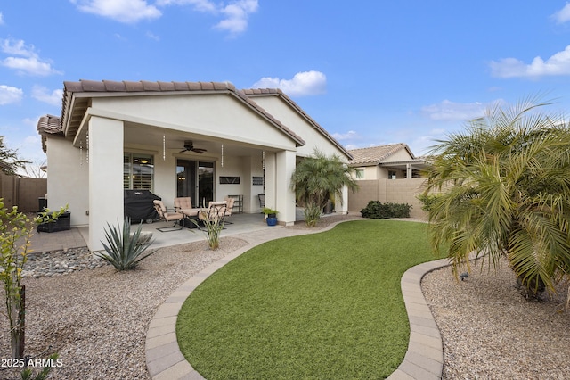 rear view of house featuring a yard, a patio area, and ceiling fan