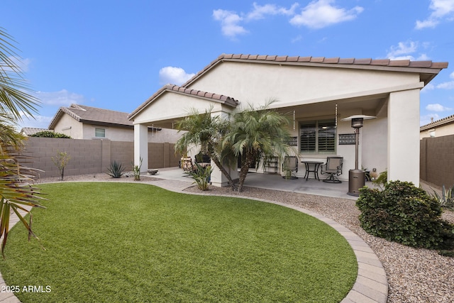 back of property with a lawn and a patio area