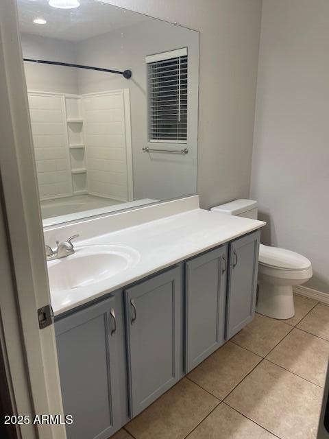 bathroom featuring vanity, a shower, tile patterned floors, and toilet