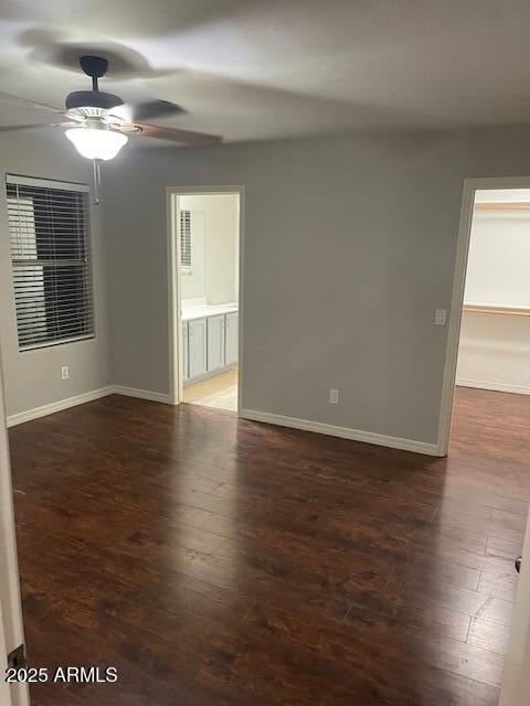 empty room featuring dark hardwood / wood-style flooring and ceiling fan