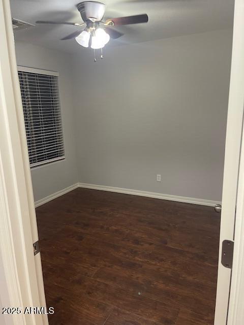 spare room featuring ceiling fan and dark hardwood / wood-style floors