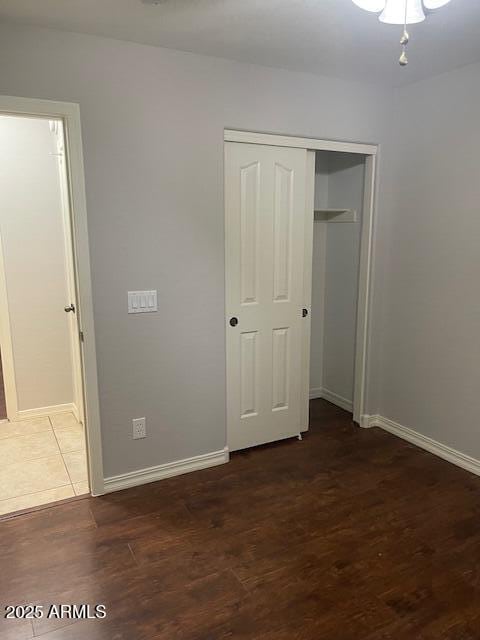 unfurnished bedroom featuring dark hardwood / wood-style flooring and a closet